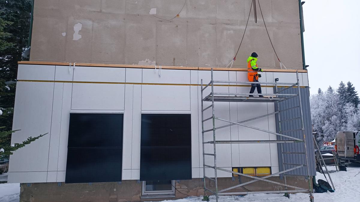 Estonian demonstrator in action, during the assembly and disassembly of pre-fabricated timber-framed insulation panels.