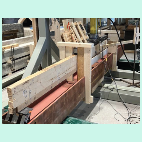 3Photograph of a beam undergoing bending tests, showing supports designed to prevent lateral-torsional buckling.